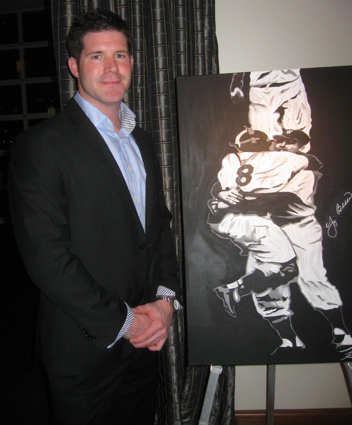Professional baseball player turned artist Kevin Rival poses with one his prize paintings
